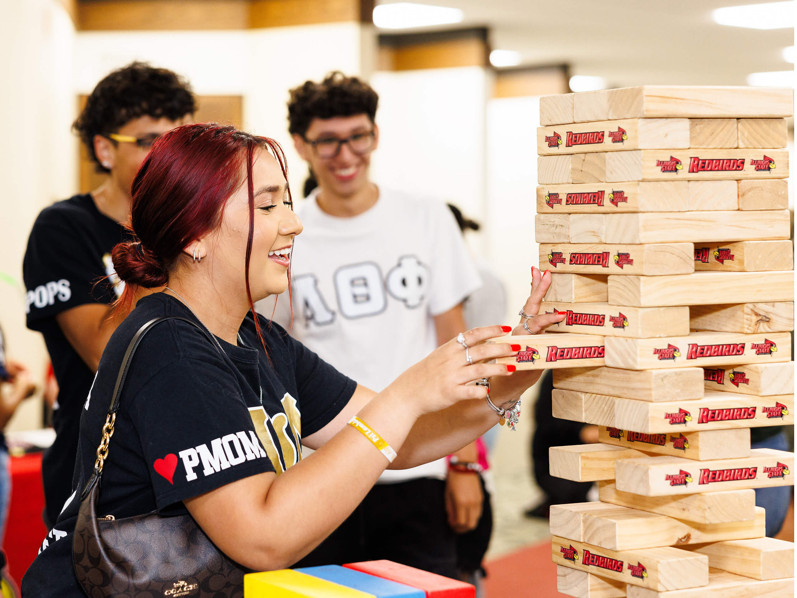 People playing a game of giant Jenga indoors.