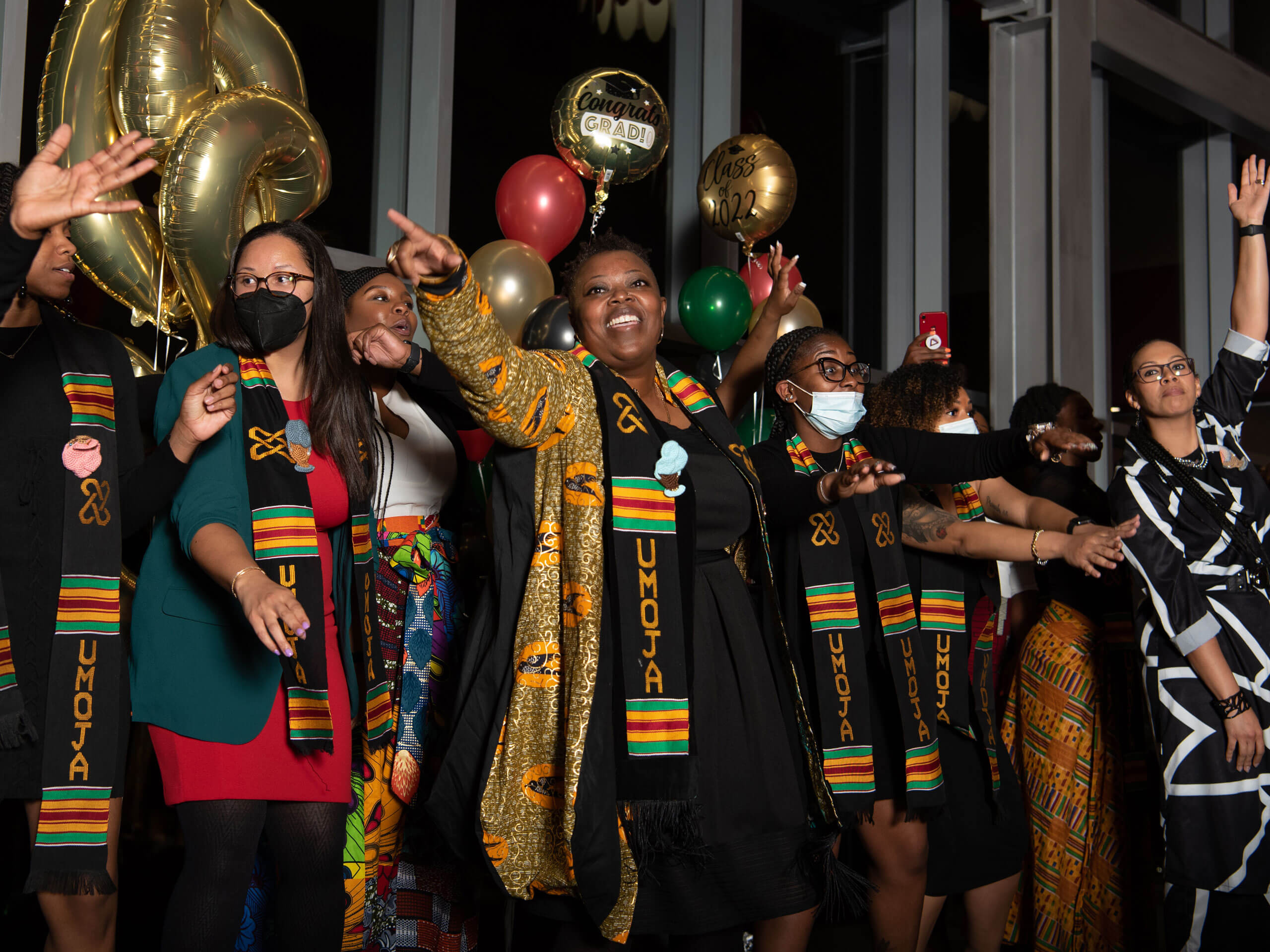 People gather onstage to celebrate during Umoja Graduation.