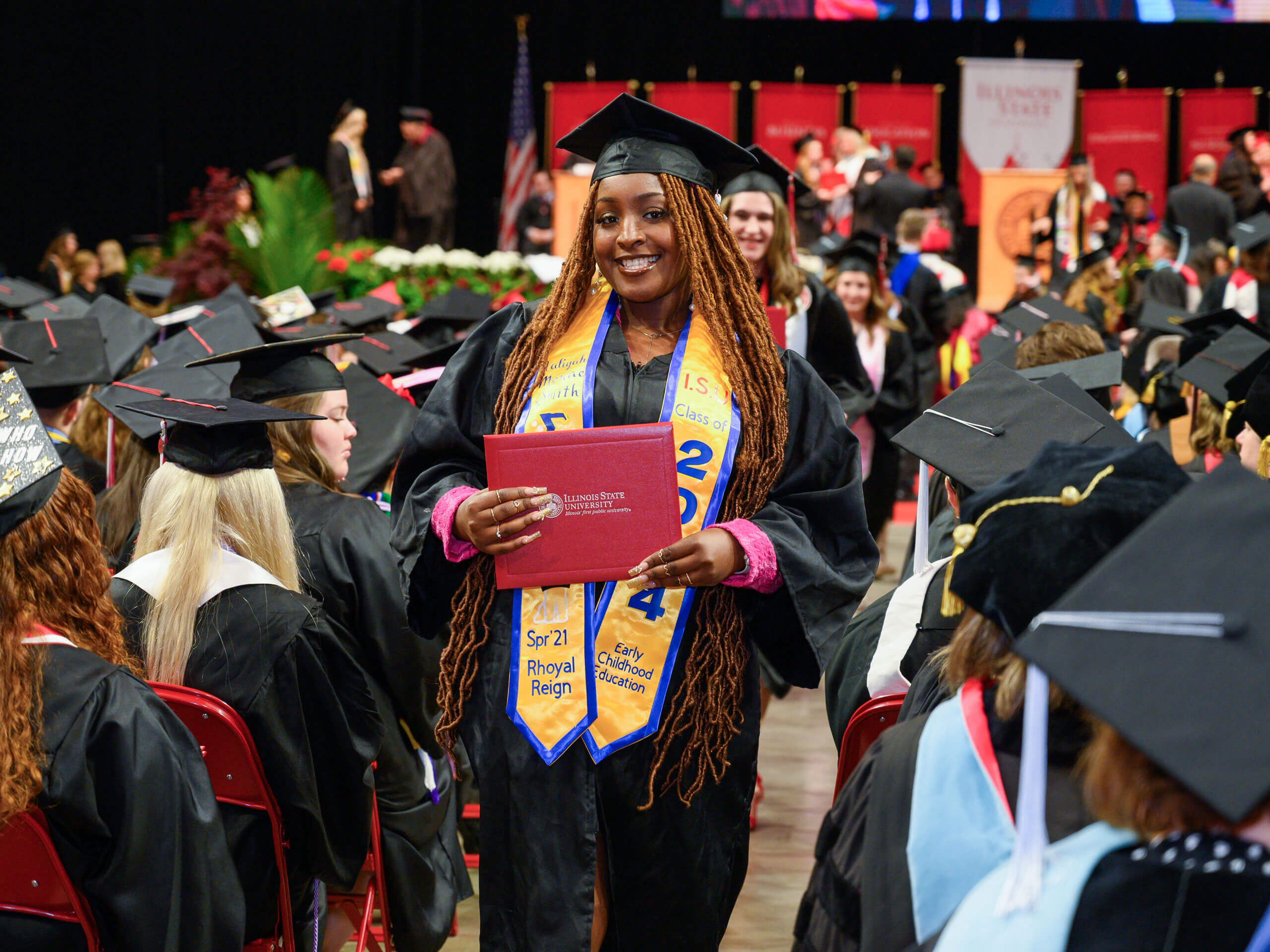 Graduates smile as they walk into the commencement ceremony.