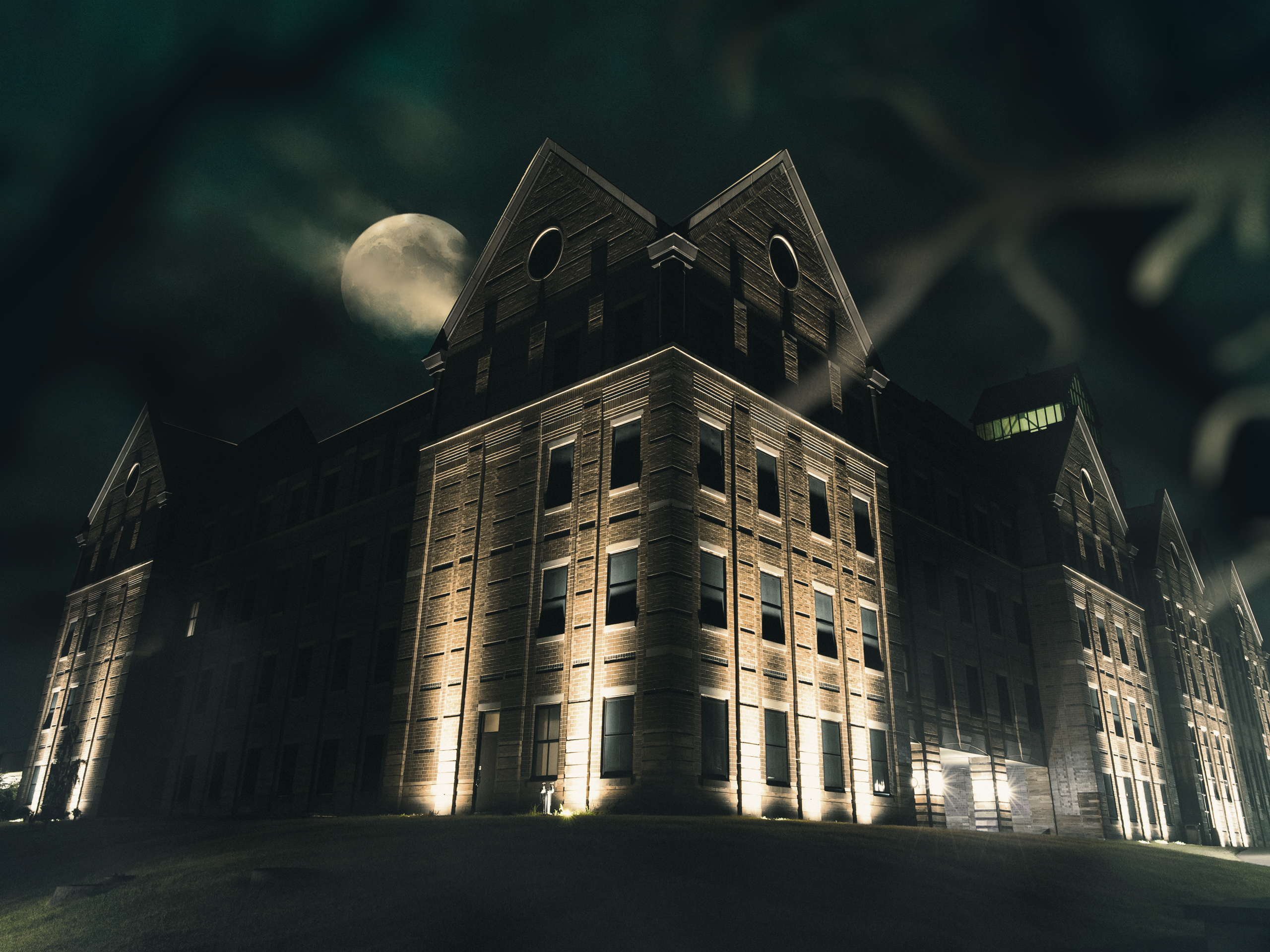 State Farm Hall School of Business at night with full moon in the background